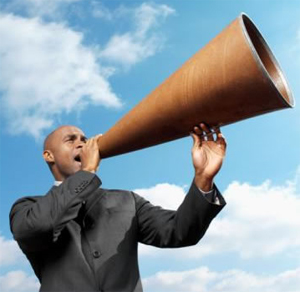 Man shouting through large megaphone outdoors.