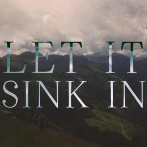 Let it sink in" over mountain landscape.