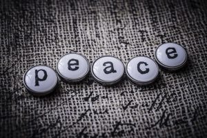 Buttons spelling "peace" on textured background.