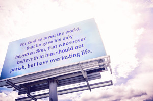 Billboard with religious text against sky.