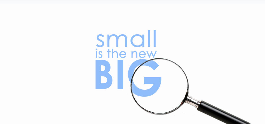 Magnifying glass with "small is the new big.