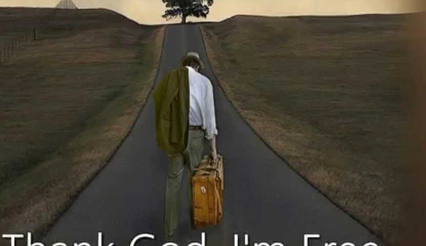 A man walking freely on an empty road under a tree.