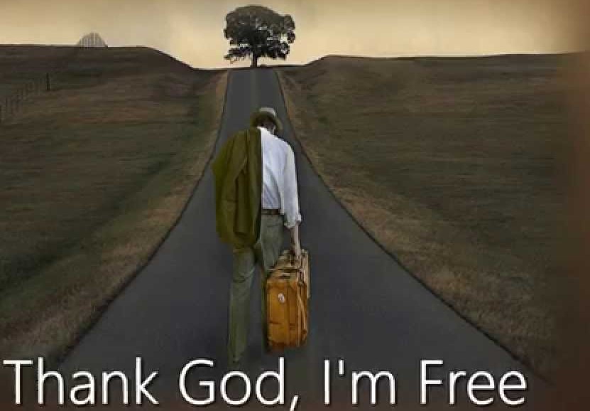 A man walking freely on an empty road under a tree.